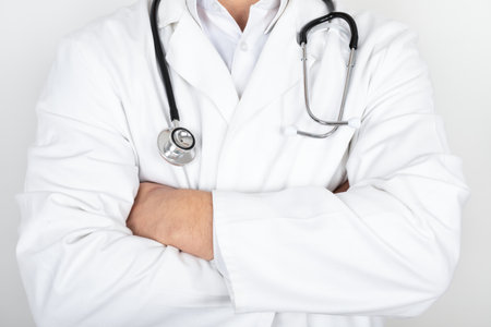 Close up picture of physicians white coat, stethoscope, having the arms crossed