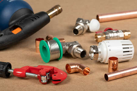 Objects of home heating system: brass valve, thermostatic valve, pipe cutter, copper plumbing partsの写真素材