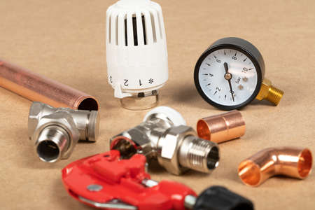 Objects of home heating system: brass valve, thermostatic valve, pipe cutter, copper plumbing parts