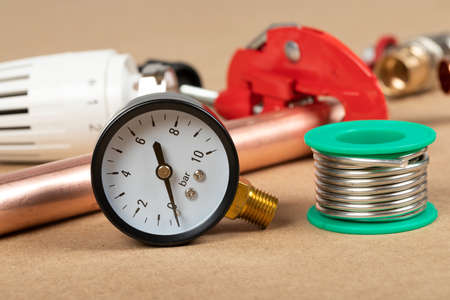 Objects of home heating system: brass valve, thermostatic valve, pipe cutter, copper plumbing parts