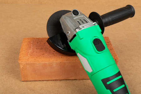 Picture of a green angle grinder on a wooden backgroundの写真素材