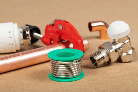 Objects of home heating system: brass valve, thermostatic valve, pipe cutter, copper plumbing parts