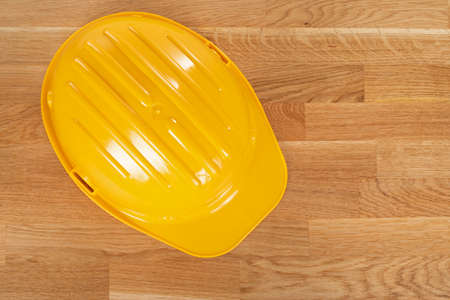 Professional yellow hard hat on wooden background. Safety at work conceptの写真素材