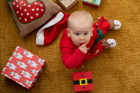 Picture of a happy baby playing with christmas gift boxの写真素材