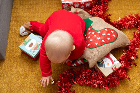 Picture of a happy baby playing with christmas gift boxの写真素材