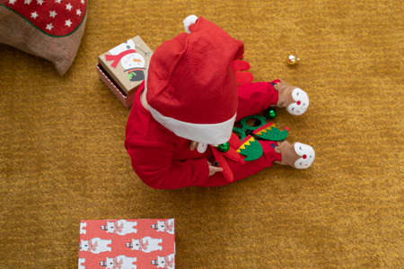 Picture of a happy baby playing with christmas gift boxの写真素材