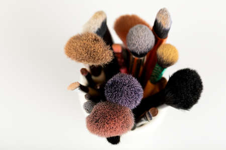 Close up picture of clean and dirty makeup brushes and accessories on white backgroundの写真素材