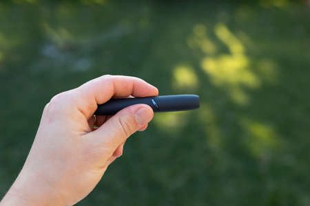 Picture of a man's hand holding an electric cigaretteの写真素材