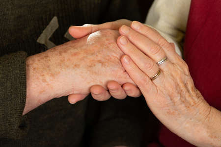 Close up picture of an old couple's hands at homeの写真素材