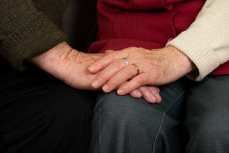 Close up picture of an old couple's hands at home
