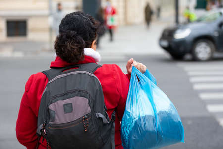 Homeless woman holding her belonging in a bag