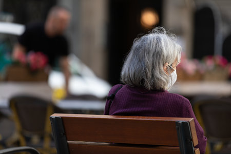 Photo of  an old lady sitting on benchの写真素材