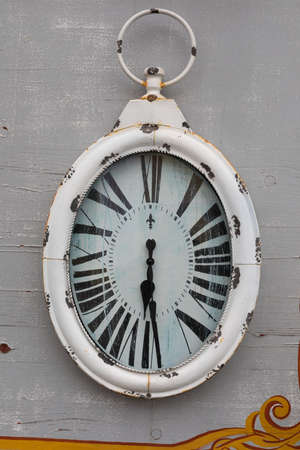 Rusty vintage clock hanging on a grai wall