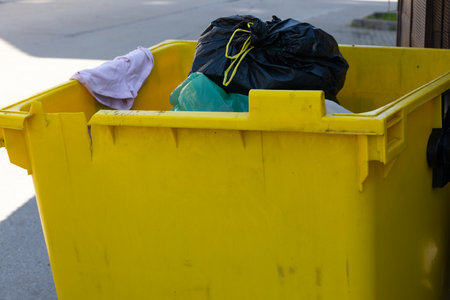 Close up picture of trash bin full of garbage on the streetの写真素材