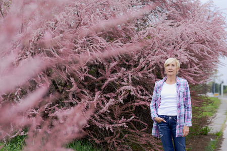 Blonde middle age woman taking a walk in park - seasonalの写真素材