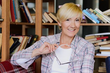 Beautiful woman with glasses reading a book の写真素材