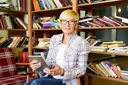 Beautiful woman with glasses reading a textの写真素材