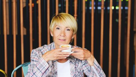 Blond woman in restaurant - having coffee の写真素材