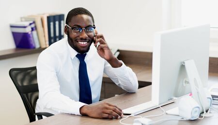 Young African American man with glasses in office の写真素材