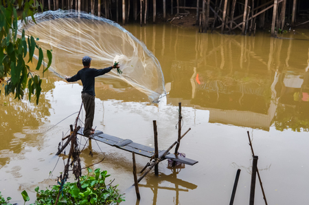 Fisherman with net fishing in Mekongの写真素材