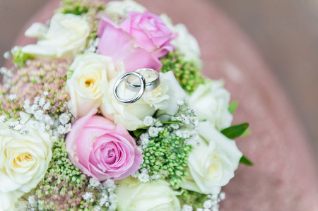 Wedding rings on bright flower bouquetの写真素材