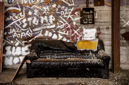 Damaged and dirty leather couch inside industrial hallの写真素材