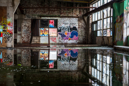 Abandoned industrial building hall with graffitiの写真素材