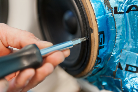 Hands of mechanical mounting speaker in car doorの写真素材