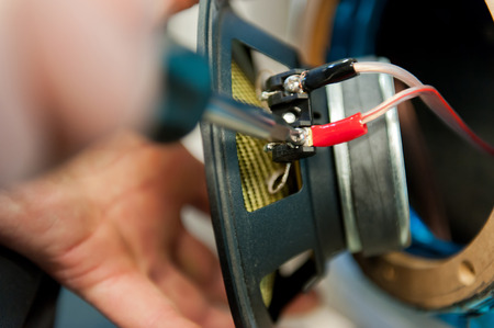 Worker hand with screwdriver on speakerの写真素材