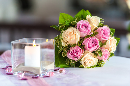 Bouquet of roses on table with candleの写真素材