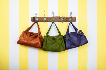 Three colored leather bags hangingの写真素材
