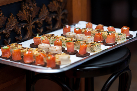 Appetizers on silver platter on wooden chairの写真素材