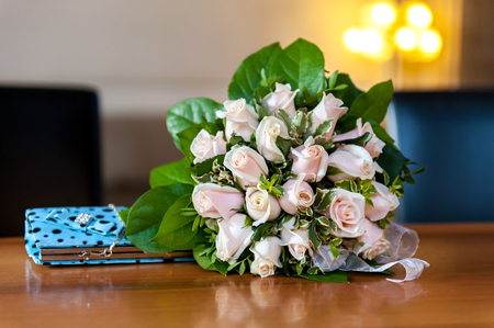 Flower bouquet and turquoise purse on wood tableの写真素材