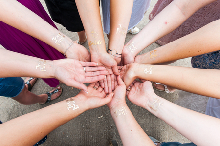 Group of woman holding hands with golden tattooの写真素材