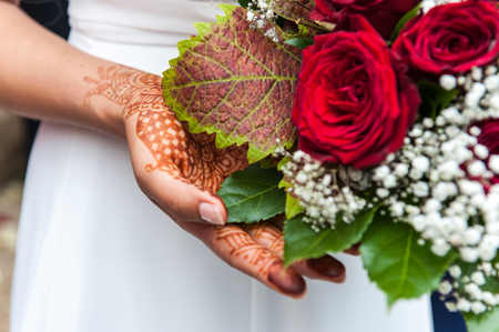 Henna on a bride`s hand with flower bouquetの写真素材