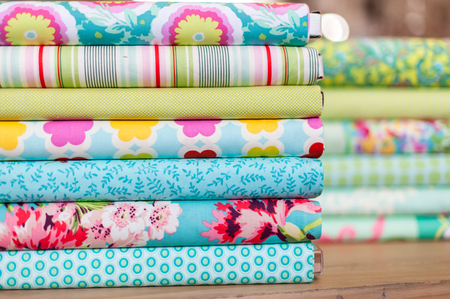 Stack of different colorful fabric rollsの写真素材