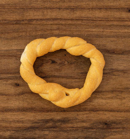 Pieces of traditional Latin American pastry called ROSQUITAS DE SAL or ROSCAS made with wheat flour. Top view of Neapolitan cookies called TARALLI. Stale salt bagels. Wood table. Ecuadorの写真素材
