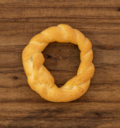 Pieces of traditional Latin American pastry called ROSQUITAS DE SAL or ROSCAS made with wheat flour. Top view of Neapolitan cookies called TARALLI. Stale salt bagels. Wood table. Ecuadorの写真素材