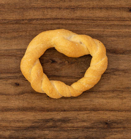 Pieces of traditional Latin American pastry called ROSQUITAS DE SAL or ROSCAS made with wheat flour. Top view of Neapolitan cookies called TARALLI. Stale salt bagels. Wood table. Ecuadorの写真素材