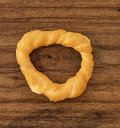 Pieces of traditional Latin American pastry called ROSQUITAS DE SAL or ROSCAS made with wheat flour. Top view of Neapolitan cookies called TARALLI. Stale salt bagels. Wood table. Ecuadorの写真素材