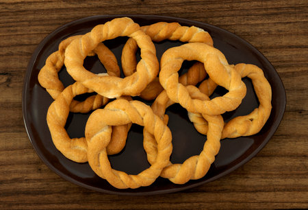 Pieces of traditional Latin American pastry called ROSQUITAS DE SAL or ROSCAS made with wheat flour. Top view of Neapolitan cookies called TARALLI. Stale salt bagels. Wood table. Ecuadorの写真素材