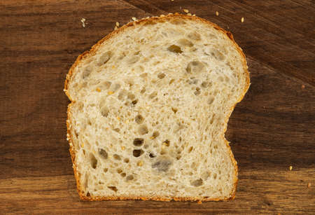 top view of a loaf of bread made from sourdough, slice of fresh bread on a wooden table. Sesame seeds on homemade bread. bakery. traditional. rustic. natural.の写真素材