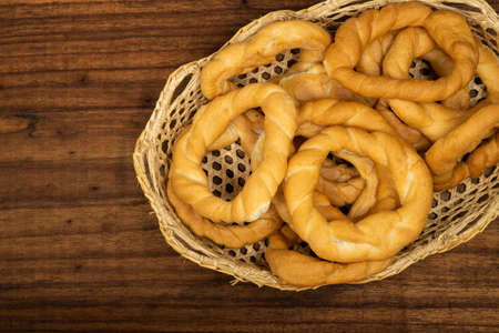 Pieces of traditional Latin American pastry called ROSQUITAS DE SAL or ROSCAS made with wheat flour. Top view of Neapolitan cookies called TARALLI. Stale salt bagels. Wood table. Ecuadorの写真素材