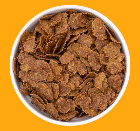 Top view of bowl with sweet chocolate cereal flakes for breakfast on white wooden backgroundの写真素材