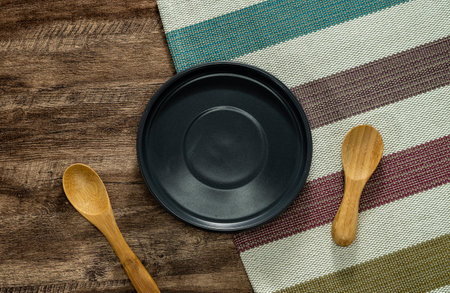 Empty plate and napkin on dark wooden table. Empty tray. Mockup for design. Top view.の写真素材