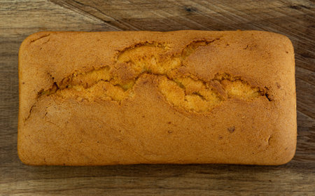 Delicious tender Madeira biscuit cake close-up on a wooden board on the table. horizontal top view from aboveの写真素材