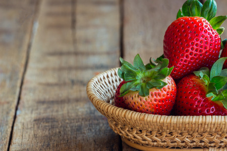 Fresh strawberries on wood background. Ripe strawberry in basket on rustic wood  table. Copy space...