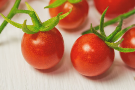 Fresh cherry tomato on rustic wood table. Close up lovely cherry tomato for background or wallpaper. Prepare fresh cherry tomato for home cooking look so delicious. Macro concept with copy space.の写真素材