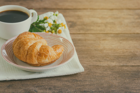 Homemade croissant on plate served with black coffee or americano. Delicious and quick breakfast...