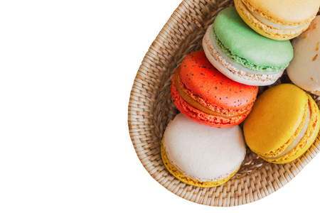 White isolated background  French or Italian macaron in top view flat lay copy space.Homemade delicious pastel color macarons on wood basket.French dessert served with tea or coffeeの写真素材